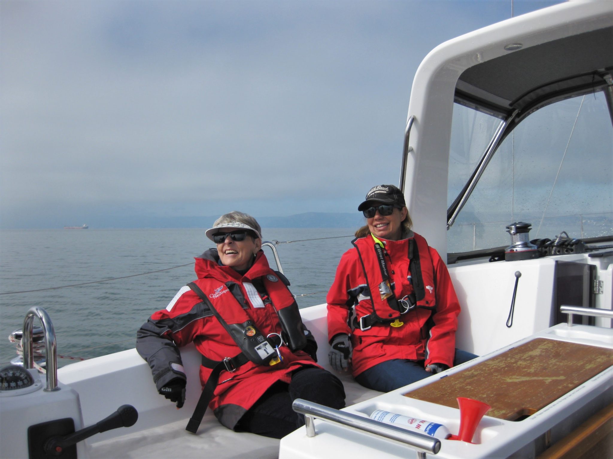 two women in red foul weather gear out for a sail
